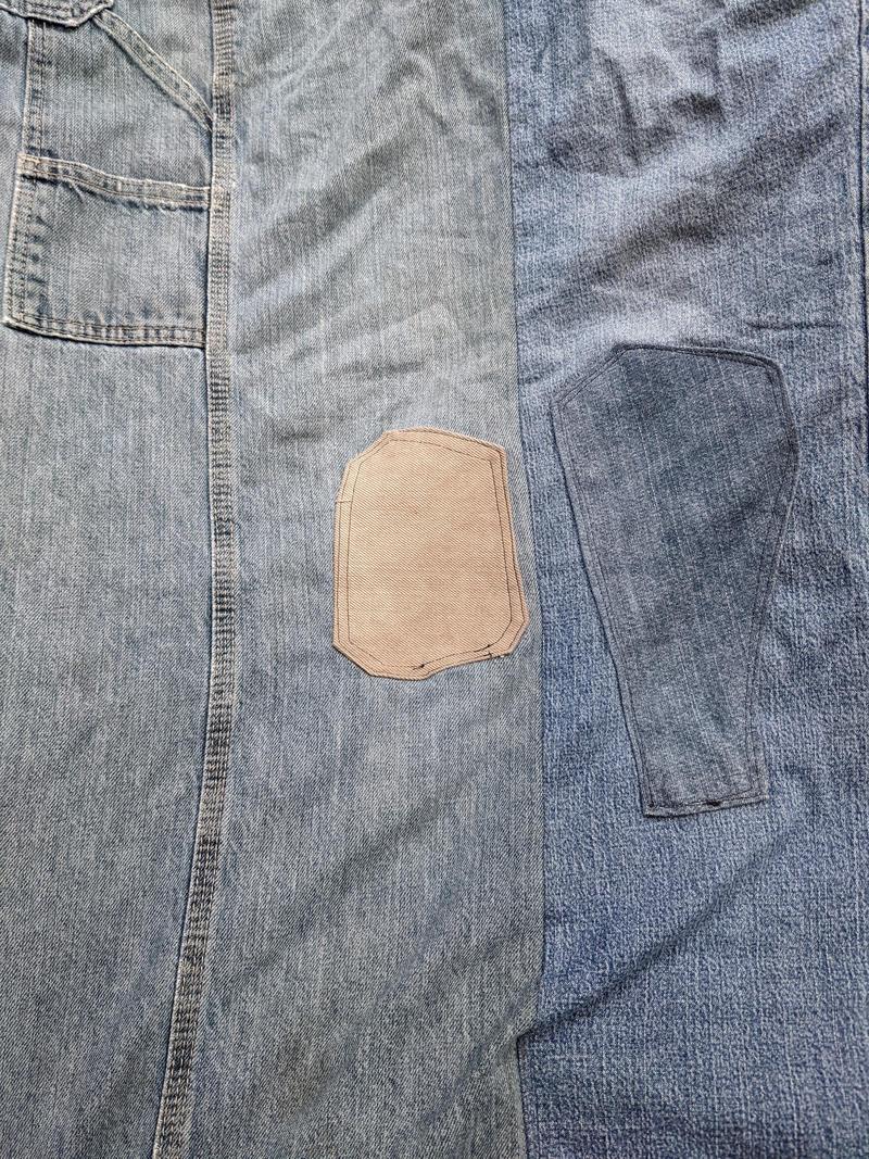 old blue jeans seen flat with patches sewn on the knees