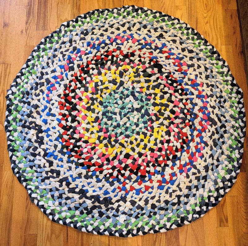 a round rag rug made from strips of old t-shirts braided together, about three feet across